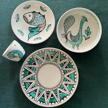 Load image into Gallery viewer, Set of ceramic plates with artistic designs on a teal fabric background
